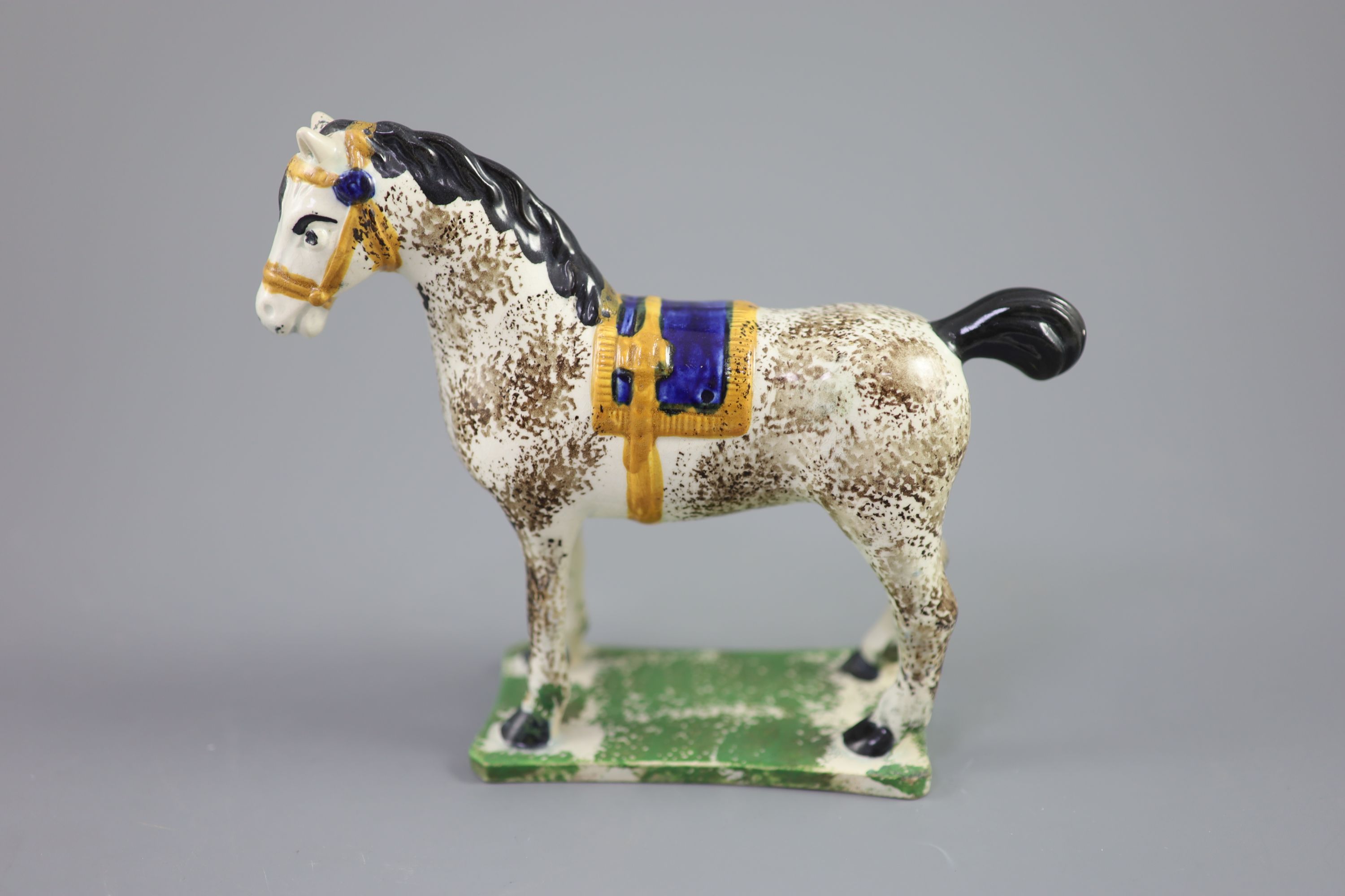 A North Country pearlware figure of a dapple horse with blue saddle, c.1800-20 14.5cm high
